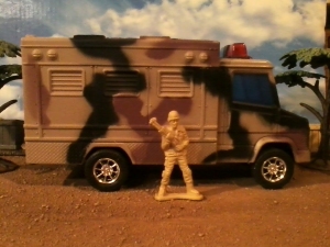The Enigmatic Camouflage/Cube Van/Ambulance/Law Enforcement Vehicle, or ECCVALEV, pictured with one of the tan's dastardly agents.